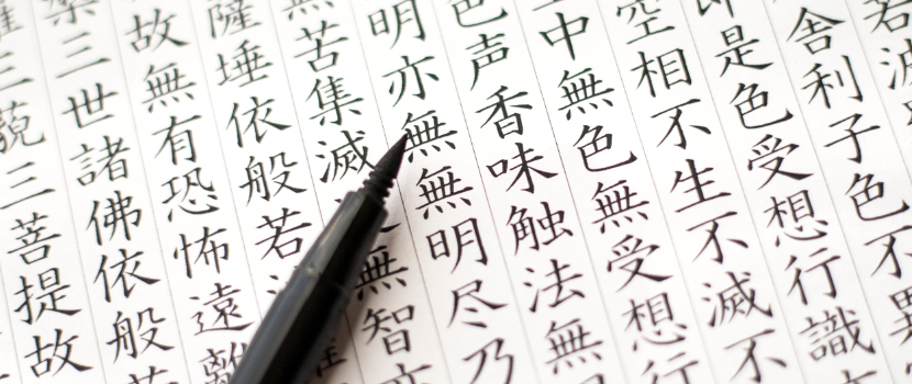 Ein Stift schreibt das chinesische Schriftzeichen „Wu“ für „kein“ oder „ohne“ wie auch „leer“ in handschriftlichen chinesischen Zeichen auf Papier.